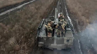 HANDOUT - Auf diesem Foto, das vom Pressedienst des russischen Verteidigungsministeriums veröffentlicht wurde, fahren Soldaten der russischen Armee mit ihrem gepanzerten Fahrzeug in Stellung und feuern auf ukrainische Stellungen an einem nicht näher…