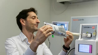 Studienleiter Pablo Sinues schliesst einen Beutel mit einer Atemluftprobe zur Analyse an ein Massenspektrometer an.
