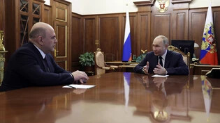 Der russische Präsident Wladimir Putin (r) spricht mit Regierungschef Michail Mischustin. Foto: Gavriil Grigorov/Pool Sputnik Kremlin/AP/dpa