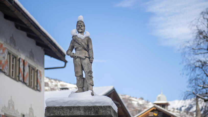 Mann im Schnee: Der Winter hat dieser Statue Hut und Kragen aus Schnee geschenkt. Die Statue ist in Fideris zu finden. 