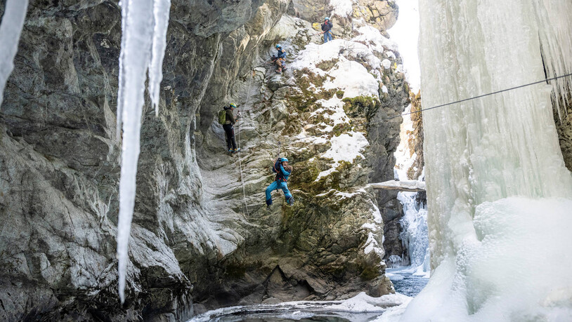 Die Bergsteigerschule Pontresina bietet Winter Canyoning an. Wer sich für dieses Abenteuer entscheidet, wandert, klettert und gleitet an eisverhangenen Felswänden und zugefrorenen Wasserfällen vorbei.