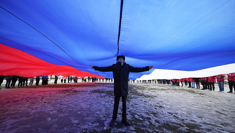 Ein Marinekadett steht unter einer riesigen russischen Flagge während einer Feier zum neunten Jahrestag der Annexion der Krim durch Russland. Foto: Dmitri Lovetsky/AP