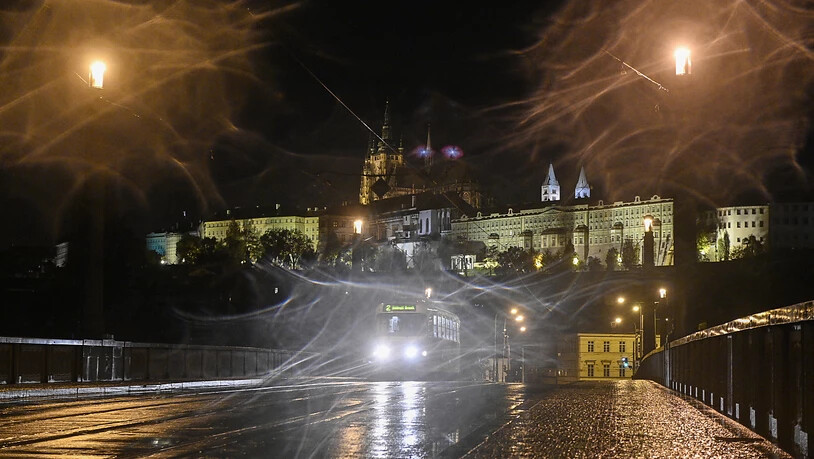 Ein Straßenbahn fährt über eine leere Straße in Prag während einer nächtlichen Ausgangssperre aufgrund einer Corona-Pandemie. Im Hintergrund die Prager Burg. Foto: Michal Kamaryt/CTK/dpa