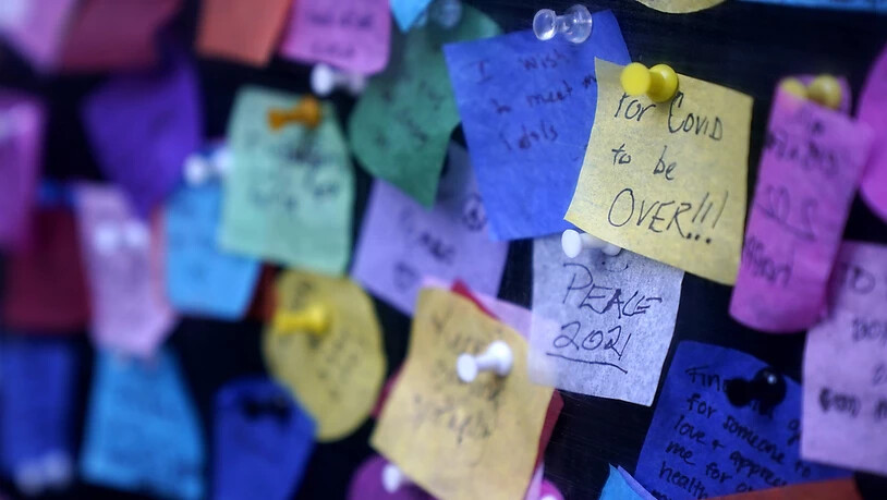Botschaften, die Menschen auf buntes Papier geschrieben haben, sind am Times Square zu sehen. Foto: Seth Wenig/AP/dpa