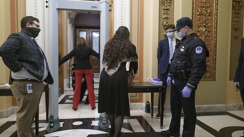 Kongressmitarbeiter gehen durch einen Metalldetektor und Sicherheitskontrolle, bevor sie die Kammer des Repräsentantenhauses betreten. Foto: J. Scott Applewhite/AP/dpa