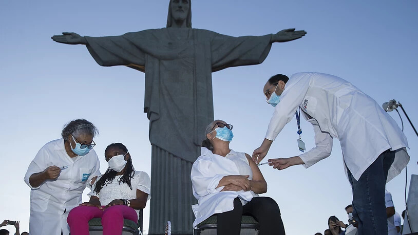 dpatopbilder - Zwei Frauen erhalten bei einm Impftermin vor der Christus-Statue eine Covid-19-Impfung. Foto: Fernando Souza/dpa