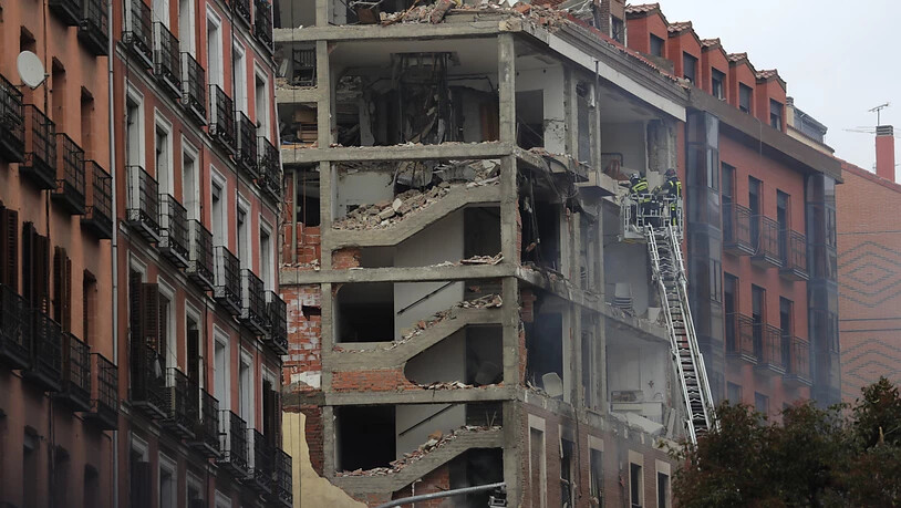 Feuerwehrleute arbeiten nach der schweren Explosion an dem beschädigten Gebäude in Madrids Toledo Straße. Foto: Manu Fernandez/AP/dpa