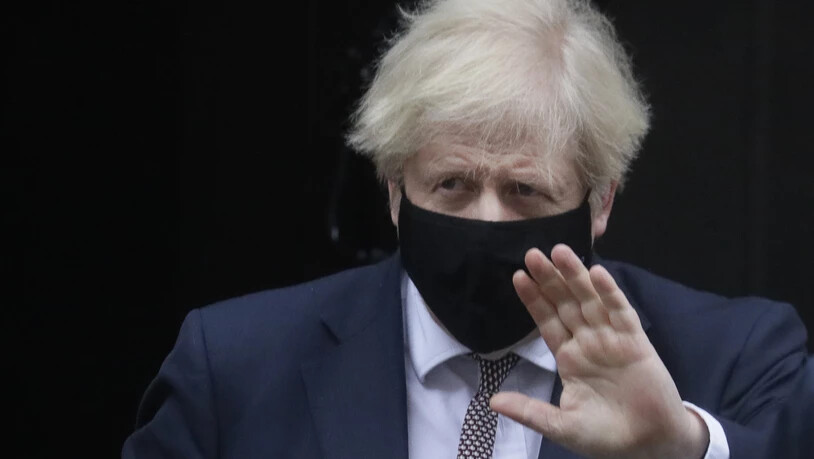 Boris Johnson, Premierminister von Großbritannien, trägt einen Mund-Nasen-Schutz und grüßt beim Verlassen der Downing Street. Foto: Kirsty Wigglesworth/AP/dpa
