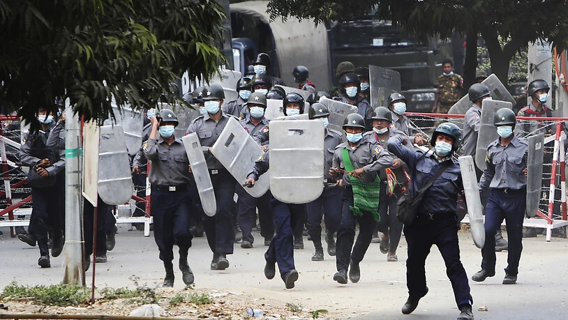 Polizisten stürmen auf Demonstranten zu, um sie zu vertreiben. Foto: --/AP/dpa