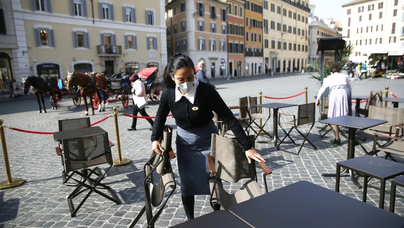 Wie geht es weiter? Eine Mitarbeiterin bereitet Tische im Außenbereich eines Cafes nahe der Spanischen Treppe in Rom vor. Die italienische Regierung plant eine neue Verordnung mit Anti-Covid-Vorlagen zu verabschieden, die vom 6. März bis zum 6. April…