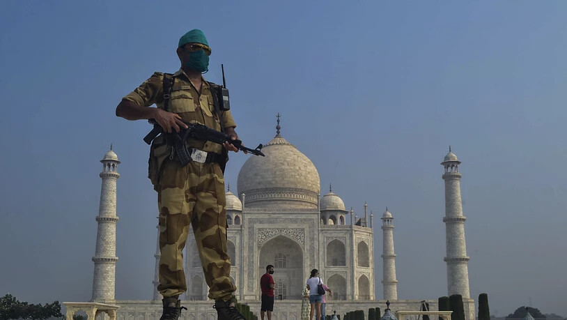ARCHIV - Ein paramilitärischer Soldat trägt eine Stoff-Maske und patrouilliert vor dem Taj Mahal. Foto: Pawan Sharma/AP/dpa