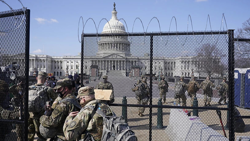 Soldaten der Nationalgarde gehen durch das Tor eines Sicherheitszauns vor dem Kapitol. Foto: Jacquelyn Martin/AP/dpa