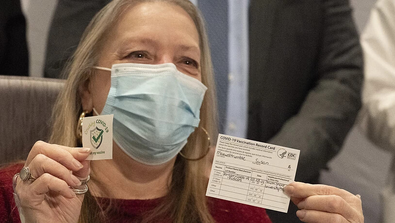 Nach der Impfung: Eine Patientin präsentiert ihren Impfausweis im South Shore University Hospital in Bay Shore im Bundesstaat New York. Foto: Mark Lennihan/AP/dpa