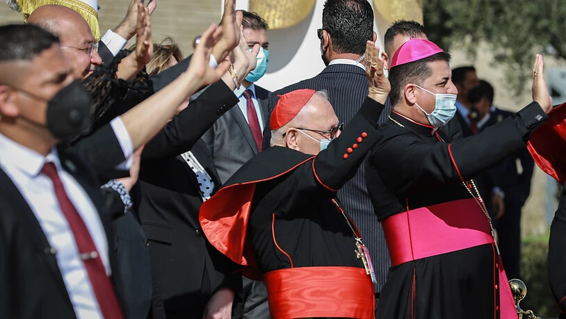 Barham Saleh (2.v.l), Präsident des Irak, und hochrangige Vertreter der katholischen Kirche winken Papst Franziskus während seiner Abflugzeremonie auf dem Internationalen Flughafen zu. Foto: Ameer Al Mohammedaw/dpa