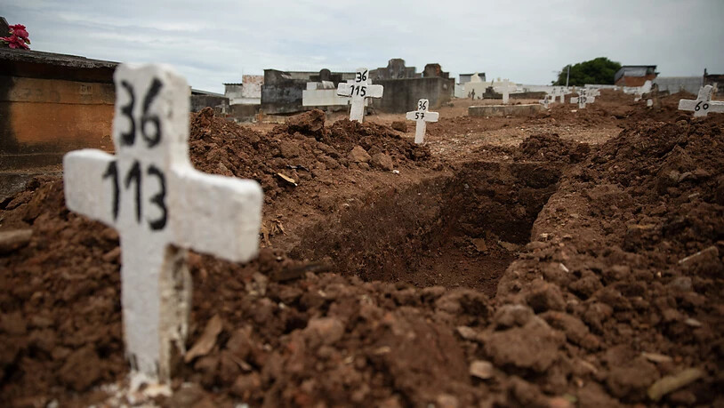 dpatopbilder - Ein einfaches Kreuz ohne Namen und mit einer Nummer steht an einem offenen Grab am Friedhof von Iraja. Foto: Fernando Souza/dpa