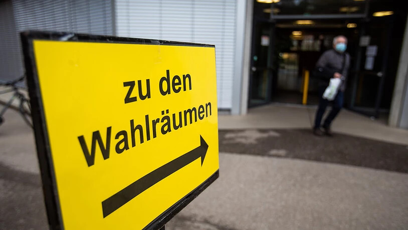 Ein Schild mit der Aufschrift "Zu den Wahlräumen" steht vor dem Wahllokal im deutsch-französischen Gymnasium in Freiburg, während im Hintergrund ein Mann das Wahllokal verlässt. Am heutigen Tag sind die Bürgerinnen und Bürgerinnen in Baden-Württemberg…
