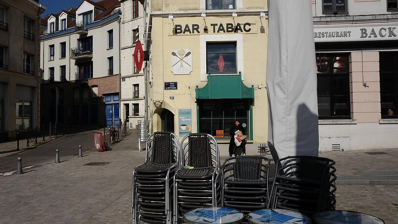 Stühle sind in einer leeren Fußgängerzone vor einem Café aufeinandergestapelt. Frankreich verhängt im Kampf gegen die Corona-Pandemie regionale Ausgangsbeschränkungen. Foto: Michel Spingler/AP/dpa