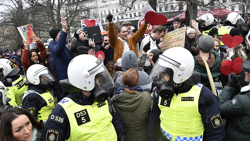Bereitschaftspolizisten stehen auf einer Straße bei einer Demonstration gegen die Massnahmen zur Eindämmung des Coronavirus. Foto: Johan Nilsson/TT NEWS AGENCY/AP/dpa