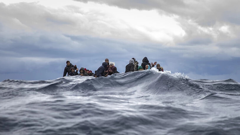 ARCHIV - Männer aus Marokko und Bangladesch sitzen in einem überfüllten Holzboot im Mittelmeer vor der Küste von Libyen. Foto: Santi Palacios/AP/dpa