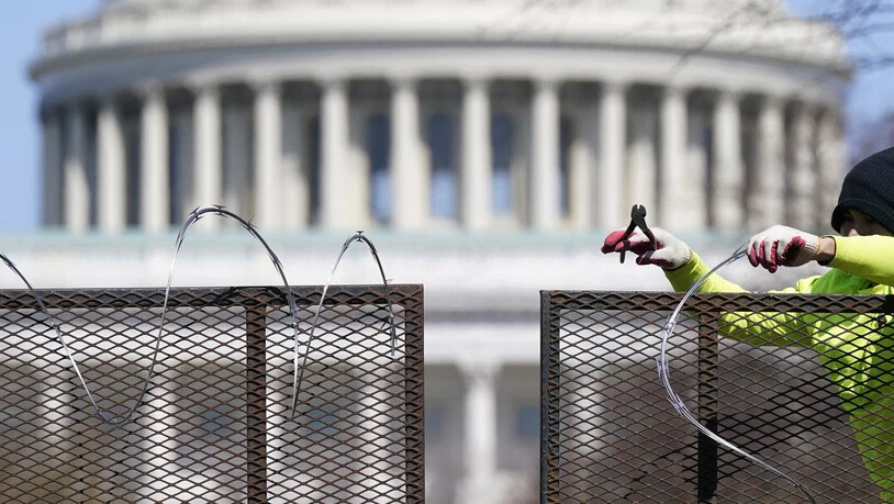 Ein Arbeiter entfernt den Stacheldraht von einem Sicherheitszaun auf dem Capitol Hill. Zweieinhalb Monate nach der Erstürmung des Kapitols durch Anhänger des damaligen US-Präsidenten Trump sind vier führende Mitglieder der rechtsradikalen Gruppe «Proud…