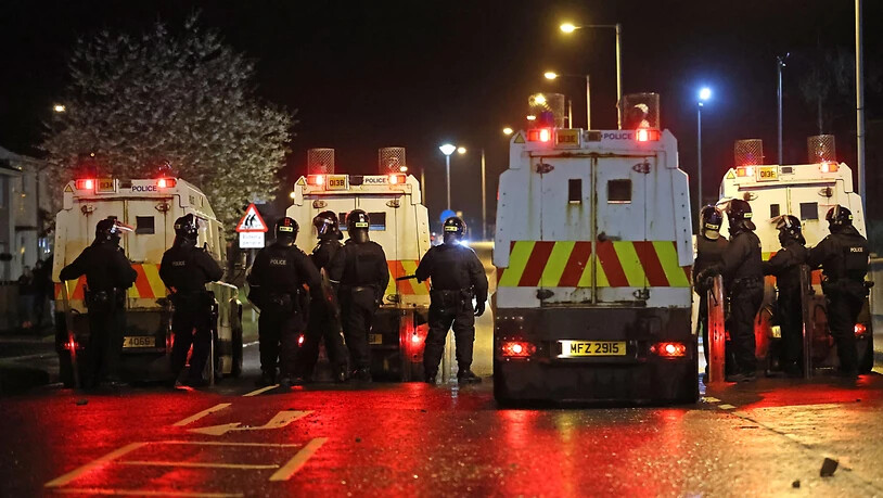 Polizisten stehen nach Unruhen auf einer Straße. In Nordirland ist es in der Osternacht erneut zu gewaltsamen Unruhen gekommen. Foto: Liam Mcburney/PA Wire/dpa