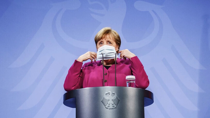 ARCHIV - Bundeskanzlerin Angela Merkel (CDU) setzt nach einem Pressestatement ihre Maske auf. Das Bundeskabinett hat die Änderung des Infektionsschutzgesetzes beschlossen. Foto: Michael Kappeler/dpa-pool/dpa