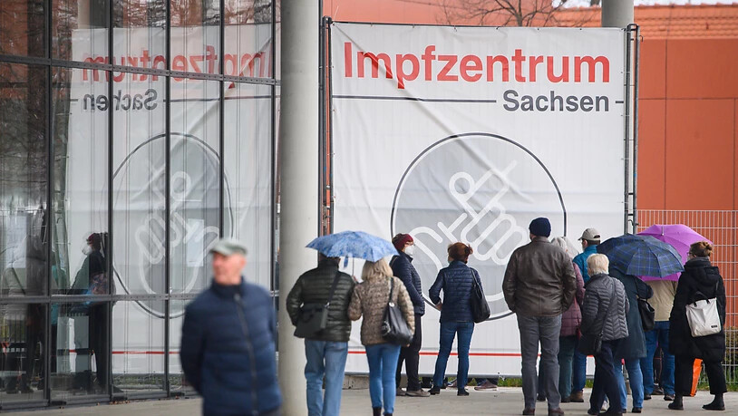 Menschen warten vor dem Impfzentrum Sachsen an der Messe Dresden. Foto: Robert Michael/dpa-Zentralbild/dpa