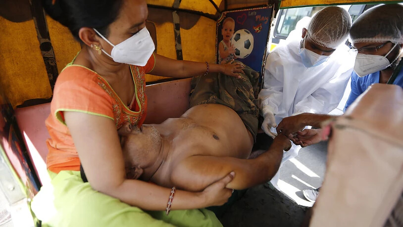 Ein COVID-19-Patient wird in einem Fahrzeug im COVID-19-Regierungskrankenhaus versorgt. Ein Feuer tötete 13 COVID-19-Patienten in einem Krankenhaus im Westen Indiens am 23.04.2021. Foto: Ajit Solanki/AP/dpa