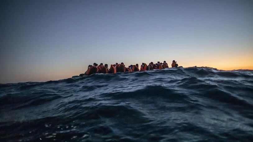 ARCHIV - Migranten aus verschiedenen afrikanischen Nationen auf einem Boot auf vor der libyschen Küste im Mittelmeer auf ihrem Weg nach Europa. Foto: Bruno Thevenin/AP/dpa