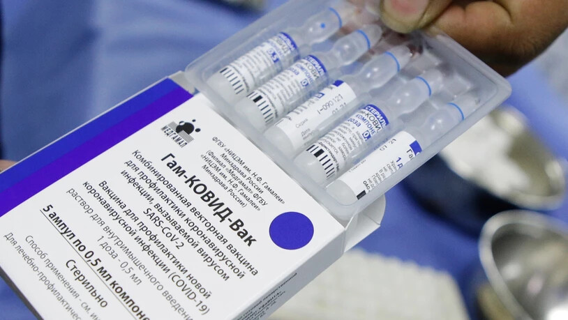 Ein Mitarbeiter des Gesundheitswesens öffnet eine Verpackung mit mehreren Dosen des Corona-Impfstoffs "Sputnik V" aus Russland. Foto: Jesus Vargas/dpa