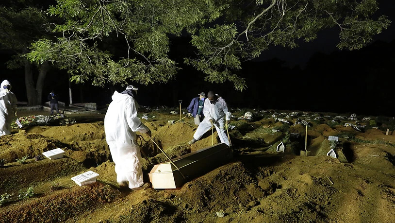 Friedhofsarbeiter in Sao Paulo begraben einen Menschen, der an Komplikationen im Zusammenhang mit Covid-19 gestorben ist. Foto: Nelson Antoine/AP/dpa