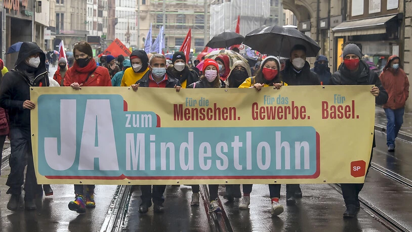 An einer Demonstration zum Tag der Arbeit demonstrierten zahlreiche Menschen mir Transparenten in Basel.