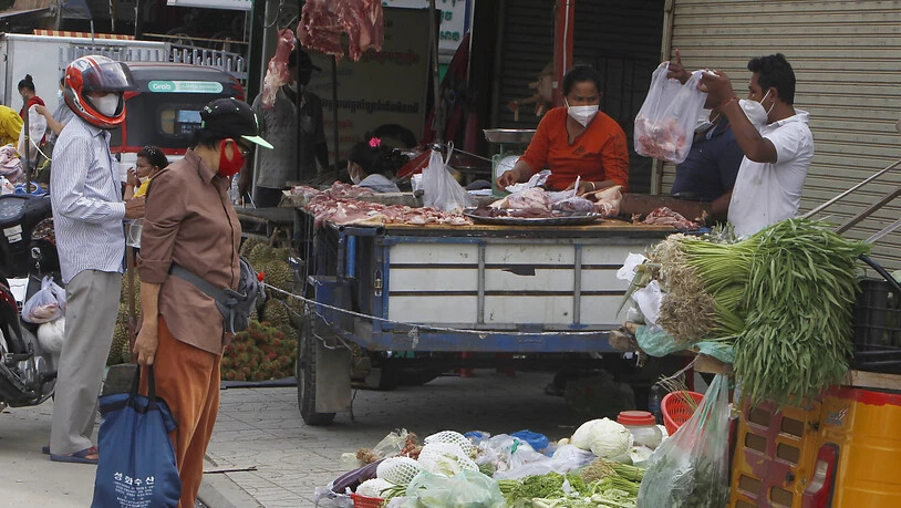 Lokale Verkäufer verkaufen ihr Gemüse, Fisch und Fleisch an einem Marktstand, nachdem ein coronabedingter Lockdown aufgehoben wurde. Foto: Heng Sinith/AP/dpa