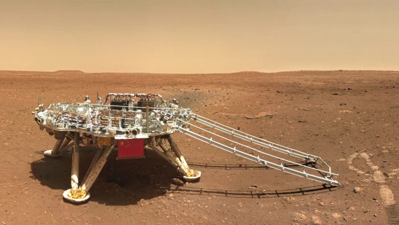 Auf dem Foto der China National Space Administration (CNSA) vom Freitag ist rechts von der Landeplattform deutlich die Spur zu sehen, welche der Rover Zhurong beim Wenden im Marssand gelegt hat. China freut sich, einen sichtbaren Eindruck auf dem Roten…