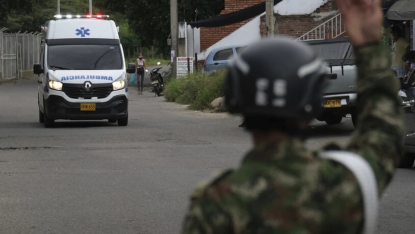 Ein Soldat gibt einem Krankenwagen Signale. Bei einem Anschlag auf einen Militärstützpunkt im Osten Kolumbiens sind dutzende Menschen verletzt worden. Foto: Ferley Ospina/AP/dpa