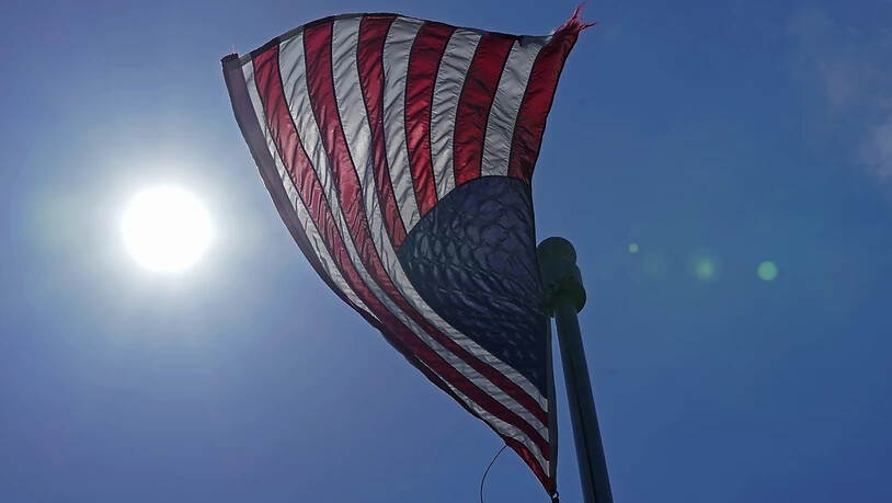 ARCHIV - Eine US-Flagge weht  mit der Sonne im Hintergrund in der Innenstadt von Seattle. Foto: Ted S. Warren/AP/dpa