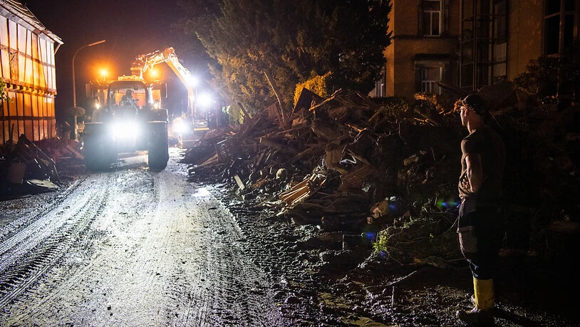 Trümmerteile werden von einem Bagger mit Anhänger im Landkreis Ahrweiler in Rheinland-Pfalz verladen. Nach der Hochwasserkatastrophe im Westen Deutschlands ist die Zahl der Toten auf mehr als 130 gestiegen. Foto: Lino Mirgeler/dpa