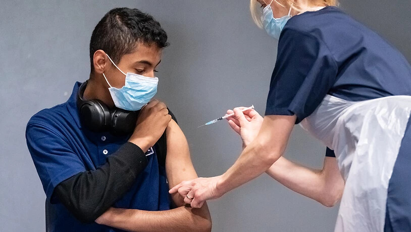 Die Krankenschwester Sonia Wilson (r) impft den 18-jährigen Cameron Ladd mit dem Corona-Impfstoff von Biontech/Pfizer in einem Massenimpfzentrum in Doncaster. Foto: Danny Lawson/PA Wire/dpa