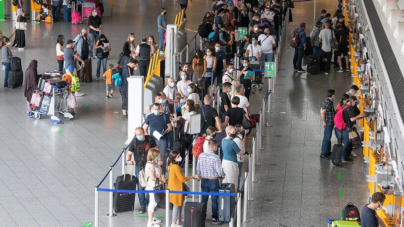 Passagiere warten auf dem Flughafen. Ab dem 1. August müssen auch Passagiere, die nach Deutschland zurückkehren, einen negativen Corona-Test vorlegen. Foto: Boris Roessler/dpa