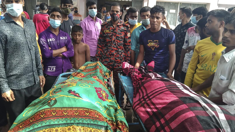 Personen stehen um die Leichen von Opfern, die durch einen Blitzeinschlag starben. Mindestens 15 Gäste sind auf dem Weg zu einer Hochzeitsfeier in Bangladesch vom Blitz getroffen worden und gestorben. Foto: Md Jahangir Alom/AP/dpa Foto: Md Jahangir Alom…