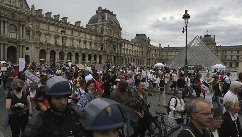Demonstranten und Demonstrantinnen nehmen vor dem Louvre-Museum in Paris an einem Protest gegen den Gesundheitspass teil. Foto: Adrienne Surprenant/AP/dpa