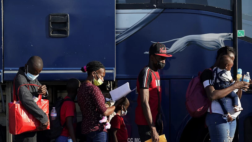 Migranten bereiten sich darauf vor, einen Bus zu besteigen, nachdem sie in einem behelfsmäßigen Lager nahe der Internationalen Brücke in Del Rio abgefertigt und entlassen wurden. Die USA wollen angesichts Tausender Migranten in der US-Grenzstadt Del Rio…