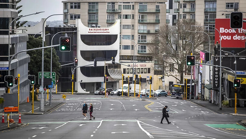 Menschen überqueren im zentralen Geschäftsviertel fast leere Straßen. Aufgrund von sinkenden Corona-Zahlen wird nach einem Monat des strengen Lockdowns in der neuseeländischen Millionenmetropole Auckland gelockert. Das teilte die Regierung am Montag mit…