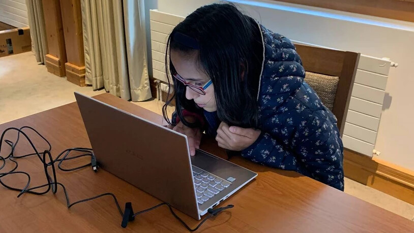 Eine Mädchen schaut konzentriert auf den Bildschirm ihres Laptops auf dem sie wie ein Profi ihren Roboter zu programmieren lernt. 