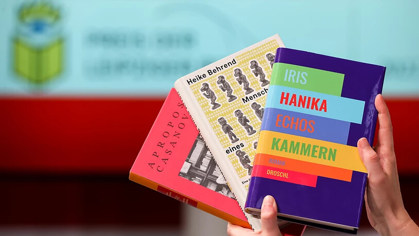 ARCHIV - Eine Frau hält die drei siegreichen Bücher beim letzten Preis der Leipziger Buchmesse, "Echos Kammern" (vorn nach hinten) von Iris Hanika, "Menschwerdung eines Affen. Eine Autobiografie der ethnografischen Forschung" von Heike Behrend und die…