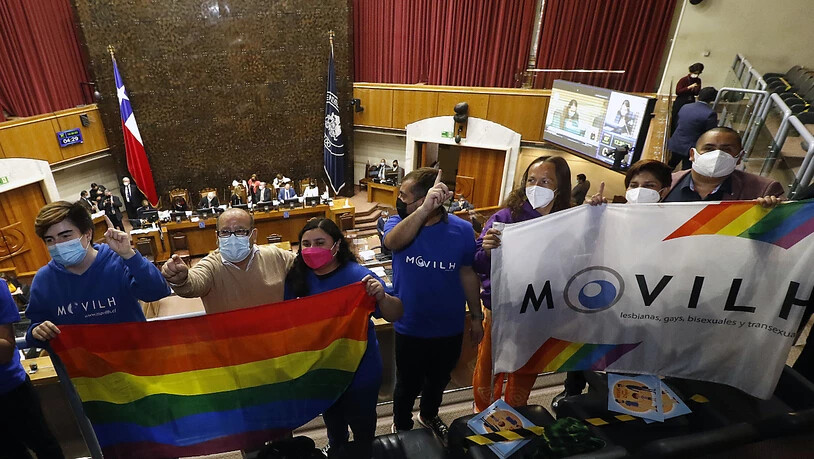 Mitglieder zweier NGOs feiern im Senat in ValparaÌso die Entscheidung f ̧r die gleichgeschlechtliche Ehe. Nach jahrelangem Ringen hat Chile Eheschlieflungen von Menschen des gleichen Geschlechts erlaubt. Foto: Leonardo Rubilar/Agencia Uno/dpa