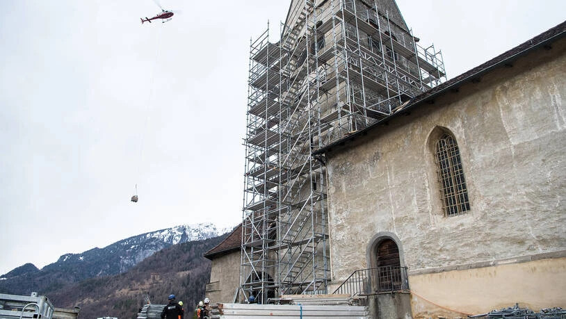 Für die Restaurierung der Baselgia Sogn Gion in Domat/Ems fliegt ein Helikopter Baumaterial heran.