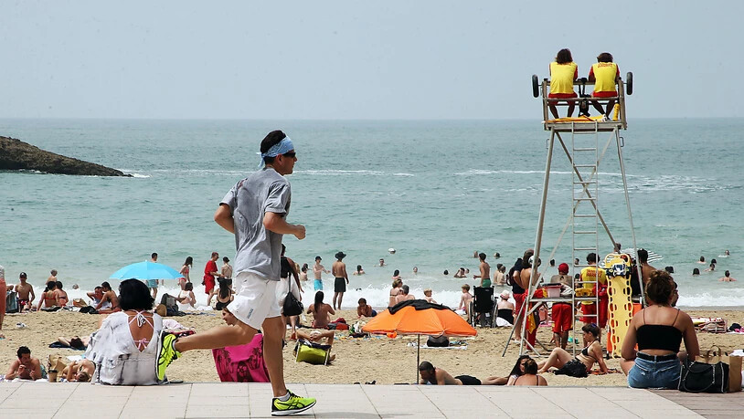 Ein Mann joggt an einem Strand vorbei. Frankreich steht in dieser Woche eine Hitzewelle mit für Mitte Juni ungewöhnlich hohen Temperaturen bevor. Foto: Bob Edme/AP/dpa