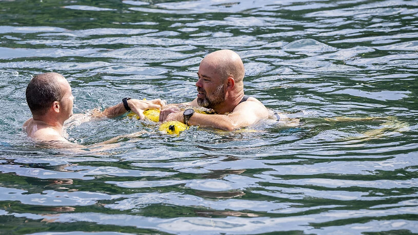 Rettungsschwimmer demonstrieren in der Rhone in Genf den richtigen Umgang mit einer Schwimmboje.