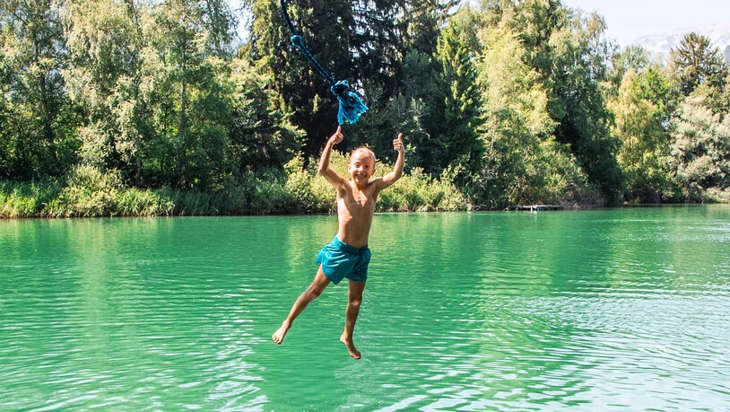 Ab ins kühle Nass: Ein Junge springt mit dem Seil ins Wasser am Canovasee.